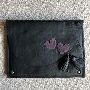Black leather clutch with tassels and hearts